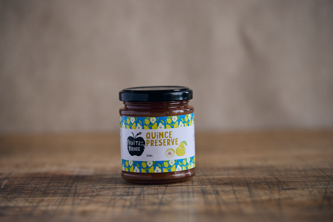 Jar of quince preserve on a wooden surface with a blurred background