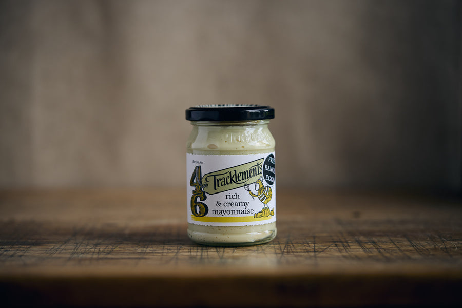 Jar of mayonnaise on a wooden surface with a blurred background